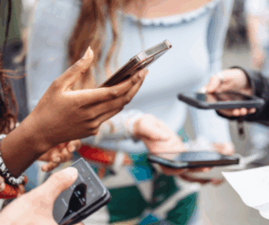 Group of people using mobile phones to view and share social media posts, representing digital engagement and event promotion.
