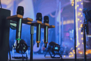 Professional event stage with wireless microphones and lighting, symbolizing the technical coordination handled by outsourced event planners.